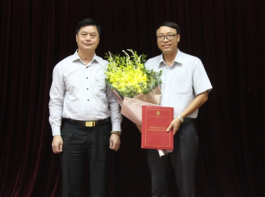 GS.TS. Phạm Văn Đức, Phó Bí thư Đảng ủy, Phó Chủ tịch Viện Hàn lâm trao Quyết định và tặng hoa cho TS. Nguyễn Huy Bỉnh,<br>tân Phó Viện trưởng Viện Từ điển học và Bách khoa thư Việt Nam